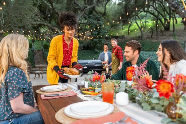 Friends and family enjoying outdoor backyard grilling and dining around a Nexgrill barbecue grill
