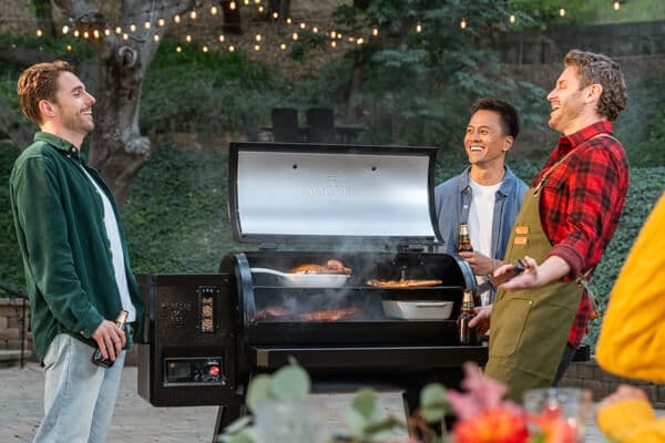 Friends and family enjoying outdoor backyard grilling and dining around a Nexgrill barbecue grill